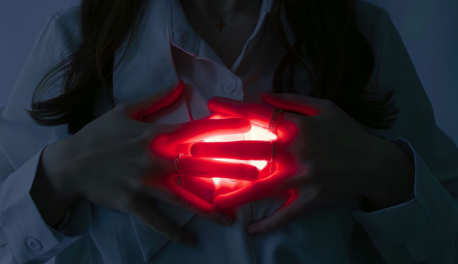 Mains en coupe autour d'une source de lumière rouge