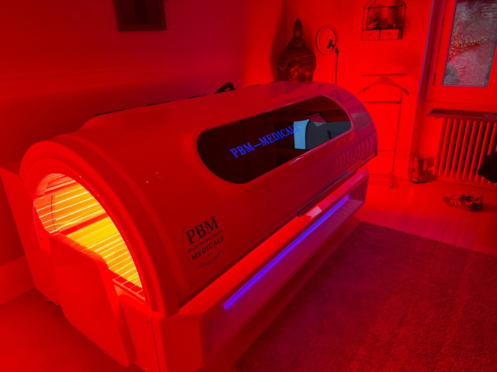 Cabine de photobiomodulation corps entier du Centre PBM Médicale, ouverte et allumée en lumière rouge